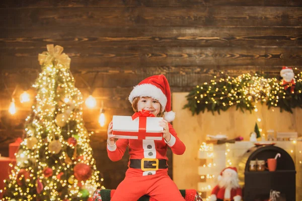 Christmas Celebration holiday. Cute little child near Christmas tree. Happy little child dressed in winter clothing think about Santa near Christmas tree. — Stok fotoğraf