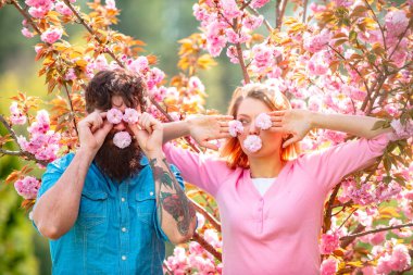 Easter couple, Romantic couple having a date in spring blooming park on a spring day with beautiful cherry blossoms in the background.