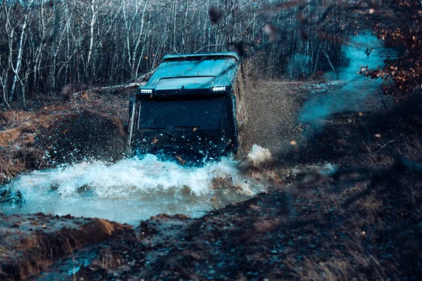 Offroad vehicle coming out of a mud hole hazard. 4x4 off-roading. Track on mud. Dirty puckup with big wheels. Best experience for the offroader. Off-road vehicle goes on the mountain. Offroad car. — 스톡 사진