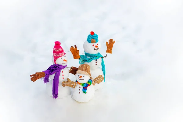 New Year banner. Funny group of snowmen family in stylish hat and scarf on snowy field. New Year greeting card. Happy snowman couple and snowman child standing in winter Christmas landscape. — Stock Photo, Image