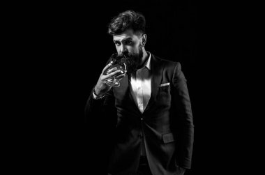 Viski barında çekici bir barmen. Elit alkolün azaltılması. Barmen deri önlüğü elinde brendi bardağı..