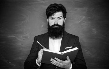 Öğretmenler günü - bilgi ve eğitim okulu kavramı. Okul sınıfında tebeşir tahtasının yanında genç sakallı öğretmen. Ders.