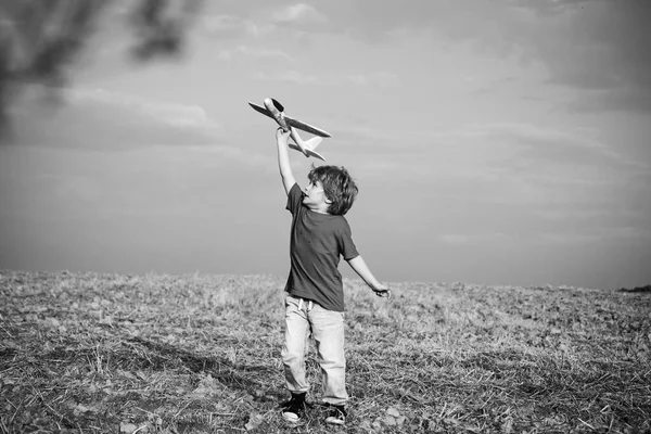 Wspomnienia z dzieciństwa. Koncepcja aktywnych dzieci. Dzieciak bawiący się zabawkowym samolotem na polu. Dziecko pilot lotnik z samolotem marzenia o podróżowaniu latem w przyrodzie. — Zdjęcie stockowe