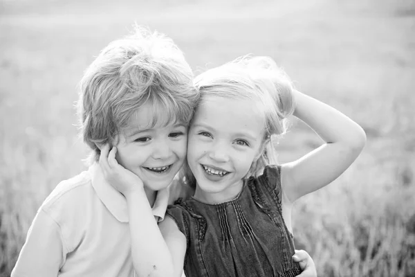 Les enfants s'amusent dans le champ sur fond de nature. Romantique et amoureuse. Un gamin qui s'amuse au printemps. Portrait d'été d'enfants joyeux et mignons. Petits enfants mignons appréciant à la campagne . — Photo