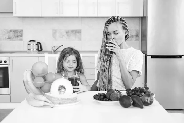 Filha e sua mãe feliz bebe smoothie verde. Refeição Vegan e menu de desintoxicação. Mãe e filha bebendo smoothie verde na cozinha. Alimentos orgânicos e vitamina para a família . — Fotografia de Stock