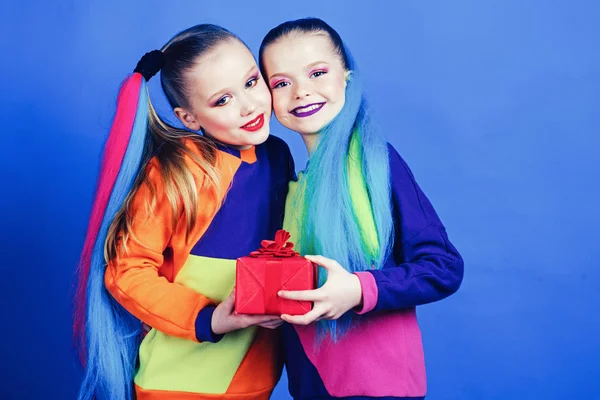 Le sorelle indossano abiti simili hanno la stessa acconciatura kanekalon trecce sfondo blu. Idea regalo di compleanno. Migliori amici di sempre . — Foto Stock