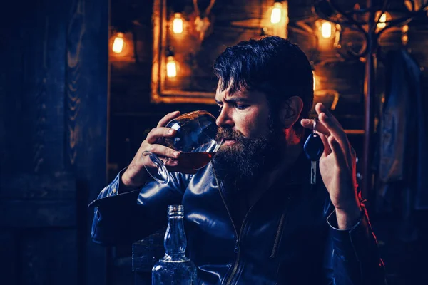 El hombre con barba sostiene brandy de vidrio. Macho bebiendo. Hombre seguro con las llaves del coche en la mano . — Foto de Stock