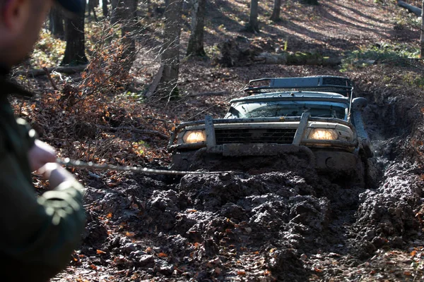 Off road car. Scene mud splash in off-road racing. Wheel in deep rut goes through mud and leaves trail. Off-road travel on mountain road.