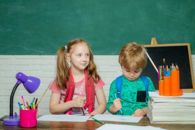 Back to school. Kids school. Happy cute industrious child is sitting at a desk indoors. Educational process.