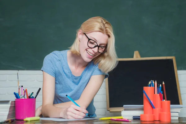University student going to college. Funny female young teacher in the classroom. Student preparing for test or exam. Young teacher. Young serious female Student studying in school.