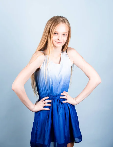 Portrait of smiling ambitious little European girl, holding hands on hips, joking and looking straight into the camera, showing up a friend who ate all cake, standing satisfied over white wall. — Stock Photo, Image