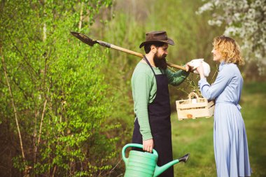 Wife and husband planting in the vegetable garden. Gardening in spring - happy couple harvesting and having lots of fun.