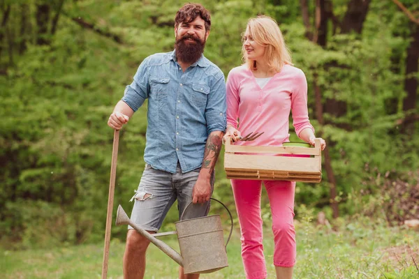 Жена и муж проводят время в саду. Фермер и его жена стоят в поле. Садоводство и концепция людей . — стоковое фото