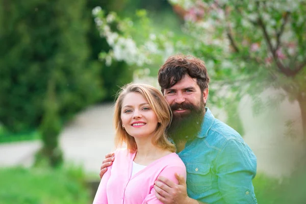 Весенняя пара смеется и обнимается. Любящий мужчина и женщина на прогулке в весеннем цветущем парке . — стоковое фото