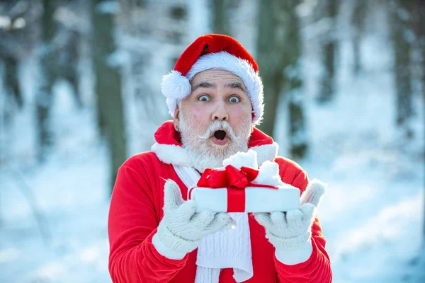 Santa Claus comes with gifts from the outside. Santa in red suit walking along the road to Christmas. New year concept. — Stok fotoğraf