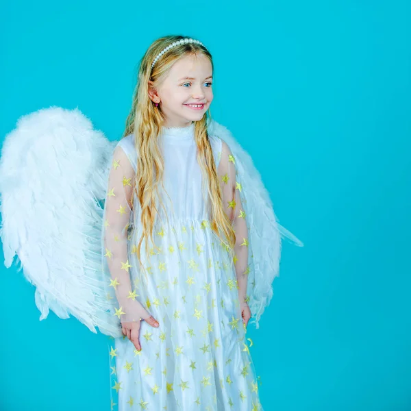 Μικρό κορίτσι άγγελος σε λευκό φόρεμα με φτερά αγγέλου σε απομονωμένο φόντο. Χριστουγεννιάτικο γλυκό αγγελούδι. Όμορφο αγγελούδι. Παιδί με αγγελικό πρόσωπο. — Φωτογραφία Αρχείου