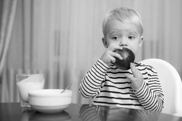 Babyvoeding. Eet gezond. Peuter neemt een snack. Gezonde voeding. Vitamine concept. Kind eet appel. Een leuke jongen zit aan tafel met bord en eten. Gezond eten. Jongen schattig baby eten ontbijt — Stockfoto