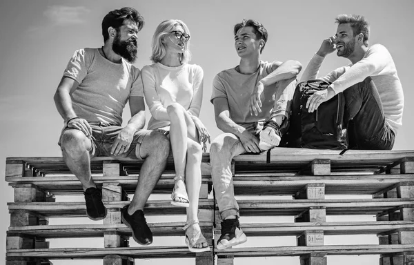 友達のグループは、ブレークして一緒に明確な空の背景に座ってチャットしている。友情と学生生活の概念。親友は余暇を屋外で過ごす. — ストック写真