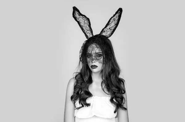 토끼 귀에 있는 욕망하는 여자의 초상화. 스튜디오에서 토끼 귀를 착용 한 젊은 여성을 촬영했습니다. 회색 배경에 검은 토끼 가면을 쓰고 포즈를 취하는 섹시 한 갈색 머리 여자. — 스톡 사진