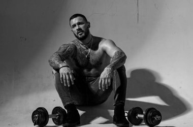 dumbell kaldırma. dövme adam seksi abs. erkek modası. atletik vücutile kaslı maço adam. halterli acımasız sporcu. Steroid. güven karizması. spor ve fitness. güçlü adam egzersiz