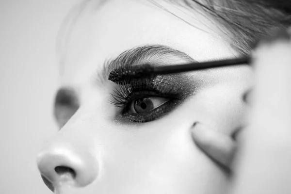 Visagistin, die die Mascara auf das Modell aufträgt. sexy lady, mode, schönheit. — Stockfoto