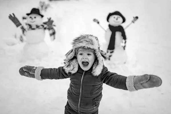 행복 한 아이의 겨울 초상화. 눈 속의 아이들. 눈내리는 겨울 산책을 하면서 눈먼 남자와 노는 행복 한아이. 아이들 이 공원에서 하얀 눈 위에서 놀고 있는 모습. — 스톡 사진