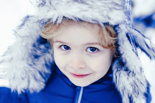 Cara de niño de invierno de cerca. Niño feliz jugando con nieve en una caminata invernal nevada. Feliz invierno. . —  Fotos de Stock
