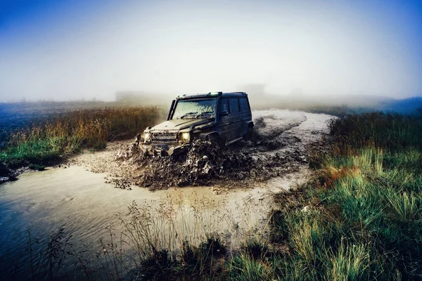 Kerék közelíti a vidéki táj egy sáros úton. Off-road jármű elakadt áthatolhatatlan út után eső a vidéken. — Stock Fotó