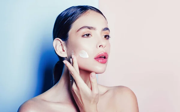 Aantrekkelijk meisje anti-aging crème op haar gezicht brengen. Closeup portret van meisje met gezonde gladde huid. — Stockfoto