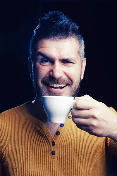 Быть в настроении кофе. Счастливый хипстер пьет кофе по утрам. Бородатый мужчина улыбается с чашкой кофе на завтрак. Наслаждаясь кофе — стоковое фото
