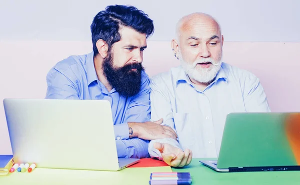 Due uomini d'affari seduti al tavolo a digitare sul computer portatile che lavorano con un nuovo business plan. Due uomini d'affari. Impiegati . — Foto Stock