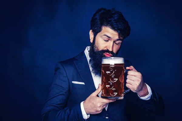 Senior man in black suit drinking beer with surprise face. Retro man with a beer. Beer time. Hipster relaxing at pub. Beer pubs and bars.