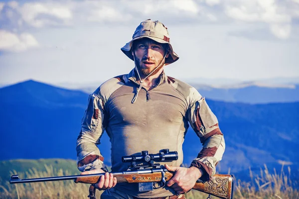 Un chasseur avec une chasse au fusil dans la forêt d'été. La chasse en montagne. Équipement de chasse et vêtements de chasse Équipement pour chasseur . — Photo