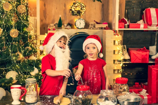 Plätzchen für den Weihnachtsmann. Lustige Kinder bereiten Lebkuchen für Weihnachten vor. Kinder kochen für Weihnachten. Weihnachtsgebäck. — Stockfoto