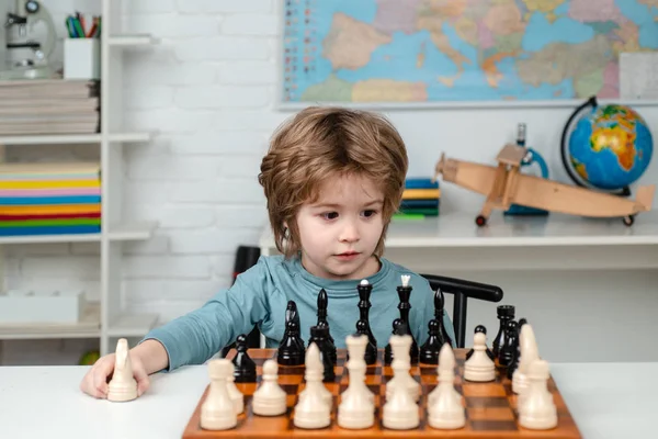 Kids early development. Pupil kid thinking about his next move in a game of chess. — Stock Photo, Image