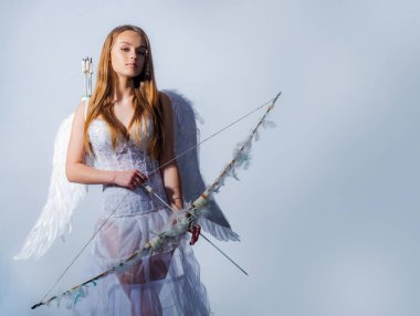 Sevgililer Günü. - Valentine. Beyaz arka plan izole. Aşk tanrısı, ok ve yayla sevimli bir melek. Sevgililer Günü kavramı. Aşk tanrısı küçük bir kızın portresi.