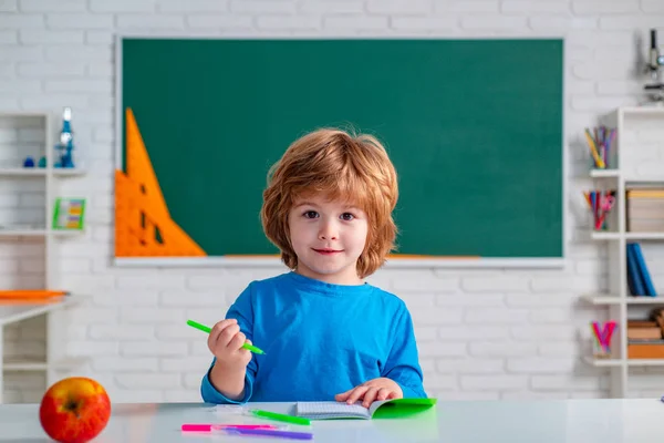 家庭教育。学校の教室で黒板の近くの子供。緑の黒板に反対する学校の子供たち。文字と数字を学ぶ. — ストック写真