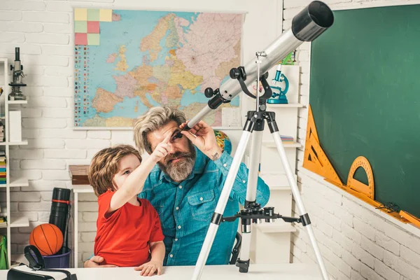 Father teaching son. Pupil learning Astronomy. Father and son pupil spending weekend together.