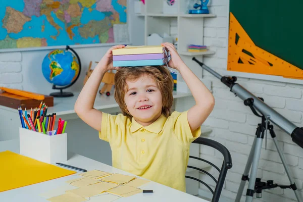Zaczynamy lekcje. Słodki chłopiec w klasie w pobliżu biurka tablicy. Przestrzeń do kopiowania tablic. szczęśliwy słodkie sprytny chłopiec z książki. — Zdjęcie stockowe