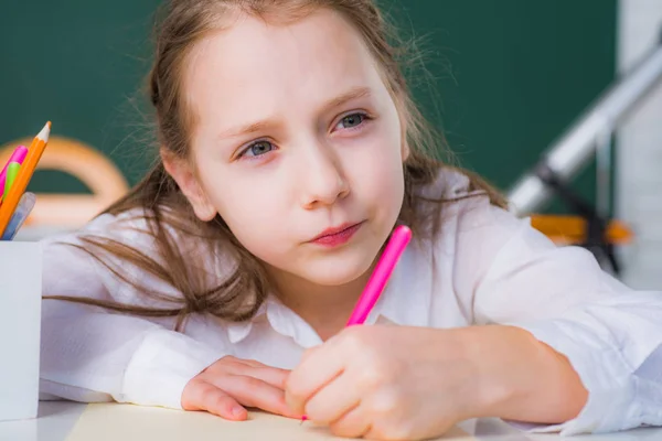 Portré egy kislányról, aki ceruzával rajzol. Az oktatás és az olvasás fogalma. — Stock Fotó