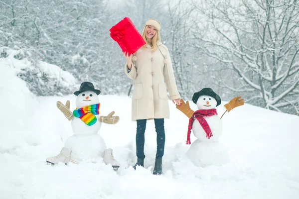 Téli háttér hópelyhekkel és hóemberrel. A lány hóemberrel játszik a téli parkban. Téli nő. — Stock Fotó