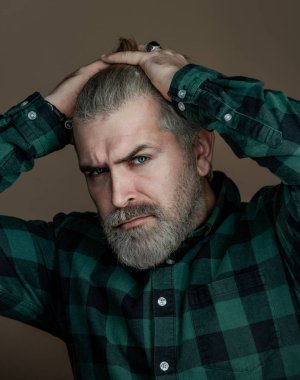 Sakallı ve son moda saç stili olan yakışıklı bir erkek portresi. Ciddi adam kameraya bakıyor..