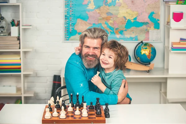 Včasný vývoj dítěte. Chytré soustředěné a přemýšlivé dítě při hraní šachů. Malý chytrý chlapec myslí na šachy. Kluk hrající šachy ve třídě. — Stock fotografie