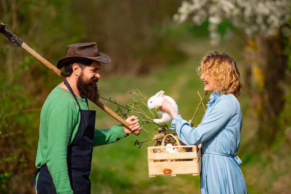 Retrato de um jovem casal feliz no quintal durante a temporada de primavera. Um par de jardineiros. Plantação de culturas em campos . — Fotografia de Stock