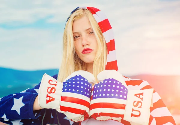 Boxeadora americana con guante de boxeo. Cuatro de Julio Estados Unidos Día de la Independencia niña Celebración Bandera Antecedentes. Mujer sosteniendo banderas americanas al aire libre en hermoso día de verano . — Foto de Stock