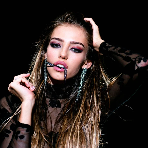 Πρόσωπο ενός όμορφου κοριτσιού με smoky eyes makeup που ποζάρει στο studio σε σκούρο φόντο. Όμορφη γυναίκα που φοράει ρούχα υψηλής μόδας. — Φωτογραφία Αρχείου