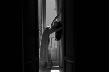 Şeffaf gecelikli kadınlar. Balkonun yanında duran genç bir kadın. Seksi gecelikli manken modeli. Çekici. Genç bir kadın poz veriyor. Güzellik ve moda.