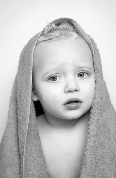 Мойте детскую гигиену, здоровье и уход за кожей. Малыш улыбается под белым полотенцем. Изображение симпатичного мальчика, покрытого игрушкой, изолировано . — стоковое фото