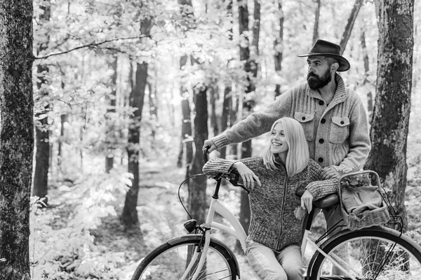 Ідеї ідеальної осінньої дати. Романтичне побачення з велосипедом. Бородатий чоловік і жінка відпочивають в осінньому лісі. Романтична пара на побаченні. Дата і кохання. Пара закоханих їздить на велосипеді разом у лісовому парку — стокове фото