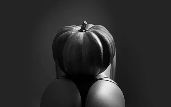 Festa di Halloween. Donna sexy con grande culo. Strega di Halloween con una zucca intagliata sul sedere. Halloween party art design. Discoteca e costume sexy. Decorazioni di Halloween festival . — Foto Stock